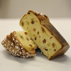Pettirosso che mangia briciole di panettone, senza canditi e cioccolato, in un contesto naturale.