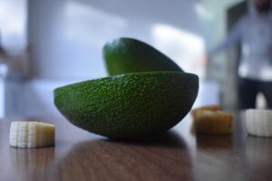 Nocciolo di avocado con tre stuzzicadenti immerso in un bicchiere d'acqua.