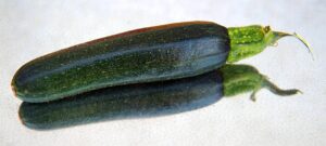 Zucchine giovani che mostrano segni di marciscenza, evidenziando il problema dell'impollinazione manuale.
